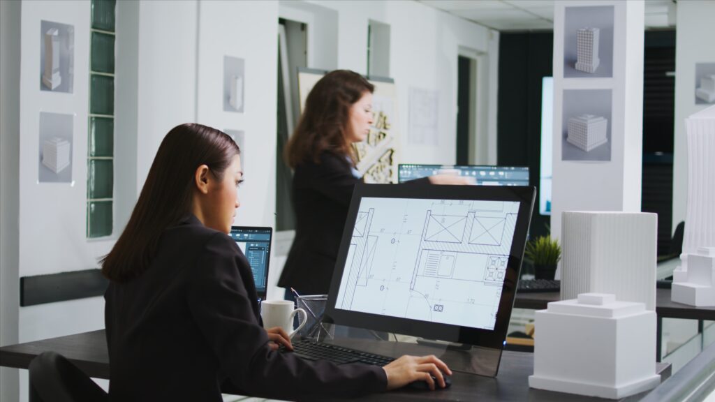 Structural design engineers working on floor plan blueprint in an office workspace