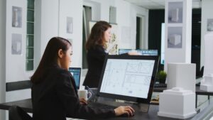 Structural design engineers working on floor plan blueprint in an office workspace